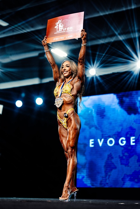 Figure competitor on stage after winning IFBB Pro card