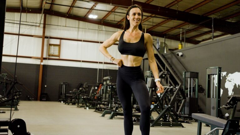 Wellness competitor Ariel working on her posing routine in the gym